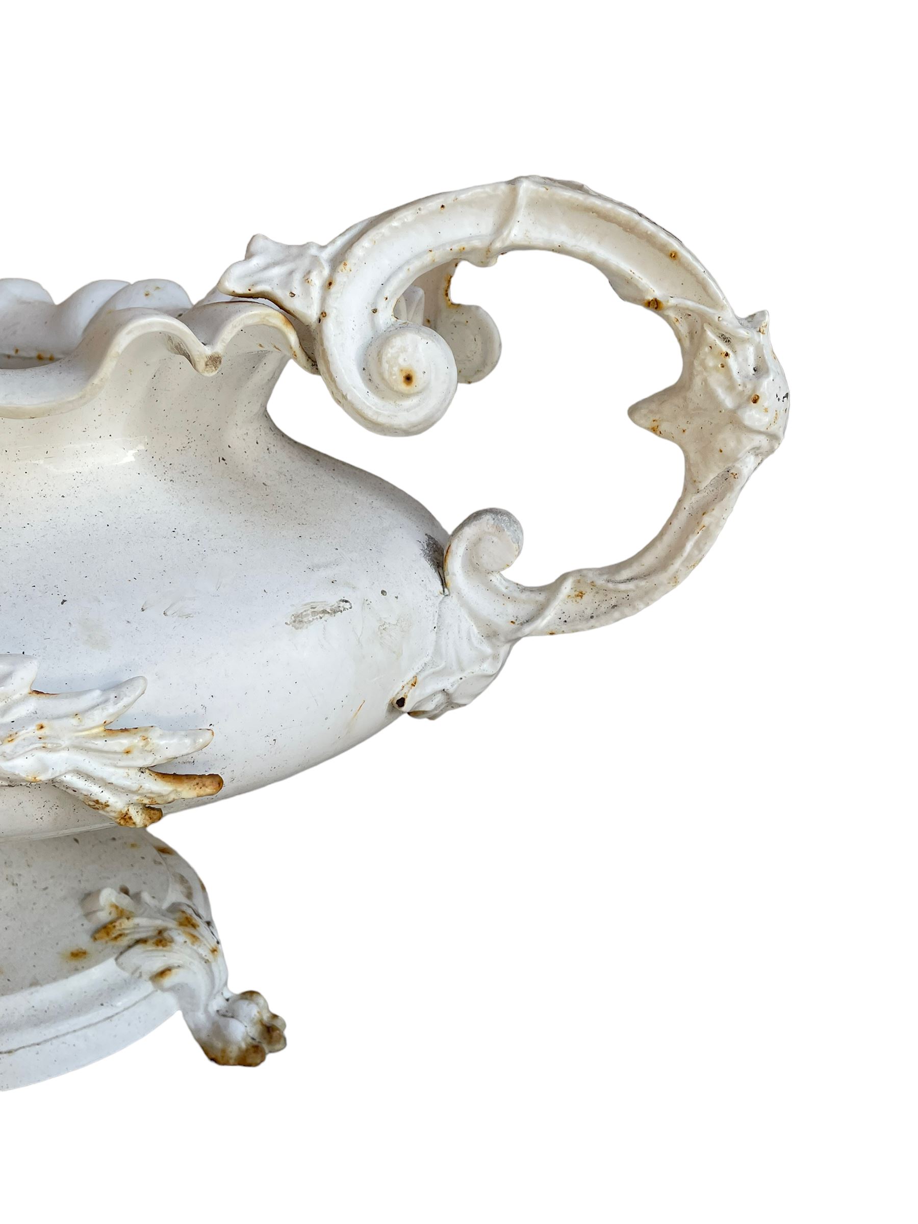 Corneau Alfred á Charleville - mid-19th century French cast iron planter, swollen and waisted oval form with scalloped upper rim, scrolled and ivy leaf cast handles, the front mounted by extending floral casting, on oval footed base with foliage and paw cast feet, the interior with drainage holes, inscribed 'Corneau Alfred á Charleville No 3' 