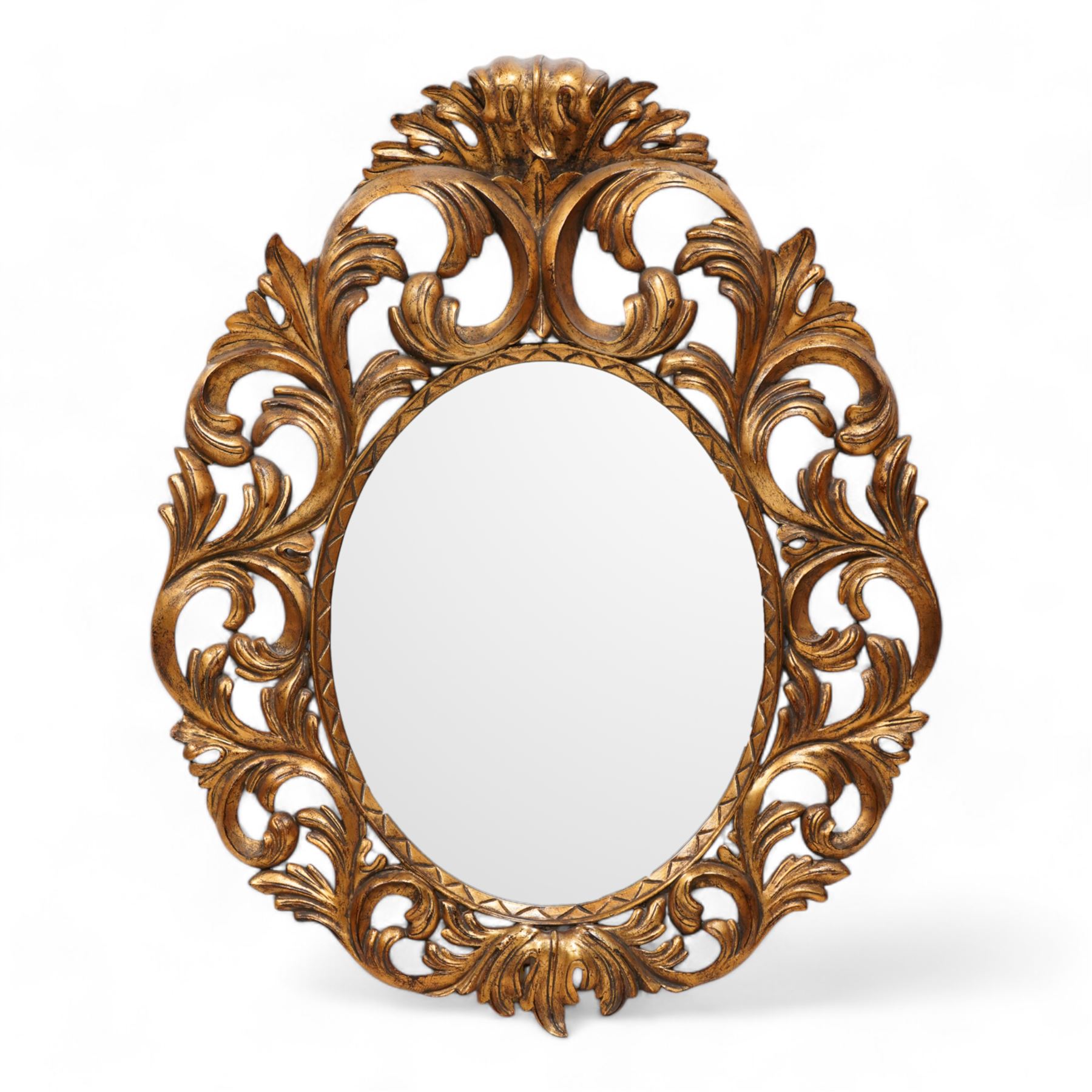 Florentine design gilt wall mirror, bevelled oval mirror plate surrounded by scrolling and interlaced acanthus leaves, curled leaf pediment 