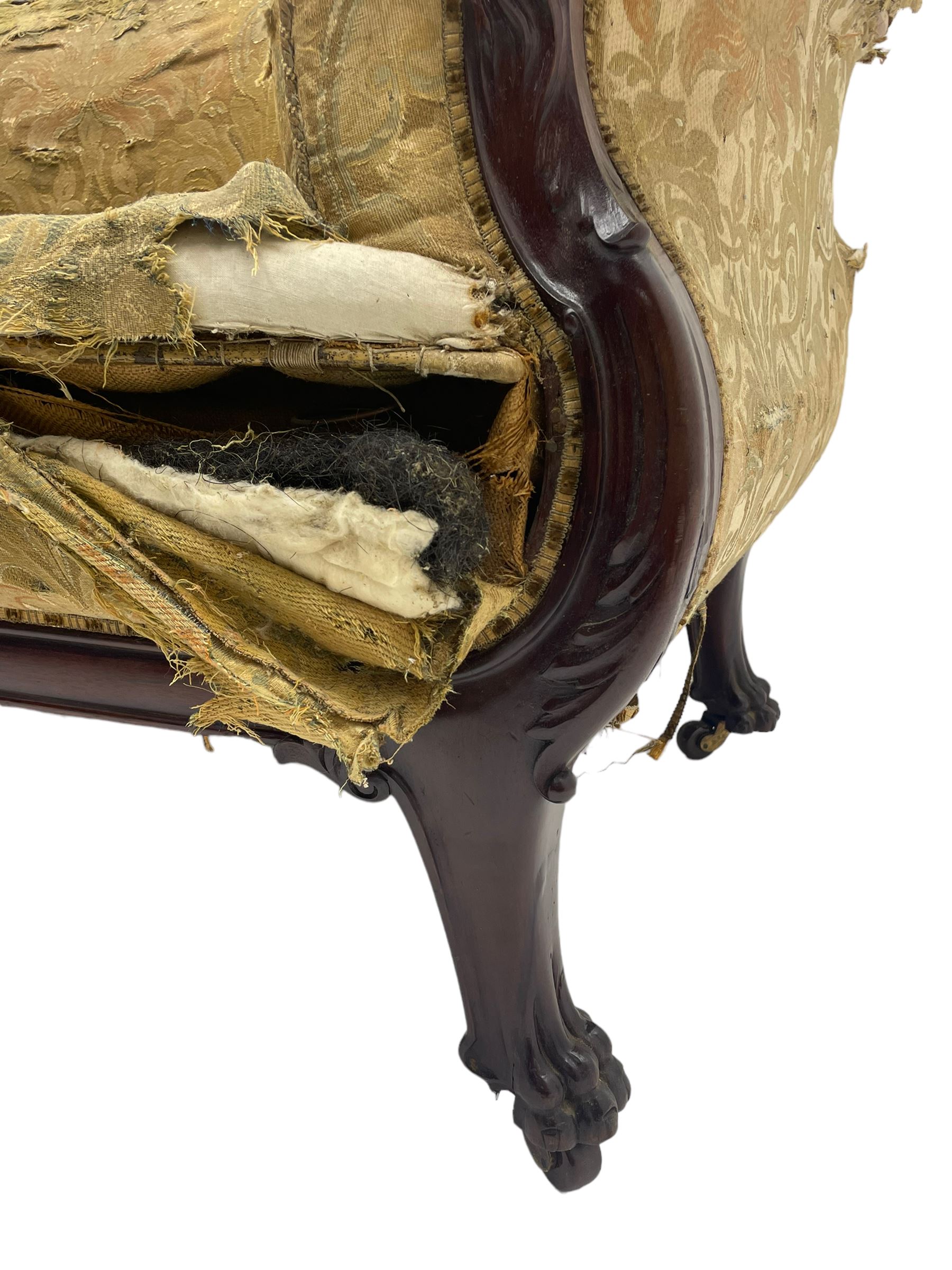 19th century mahogany settee, rolled S-scrolled arms carved with lion masks and acanthus leaf scrolls, the lower moulded rail carved with scrolling design, raised on carved paw feet with recessed brass and ceramic castors 