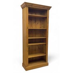 Georgian design pine open bookcase, projecting dentil cornice over five adjustable shelves...