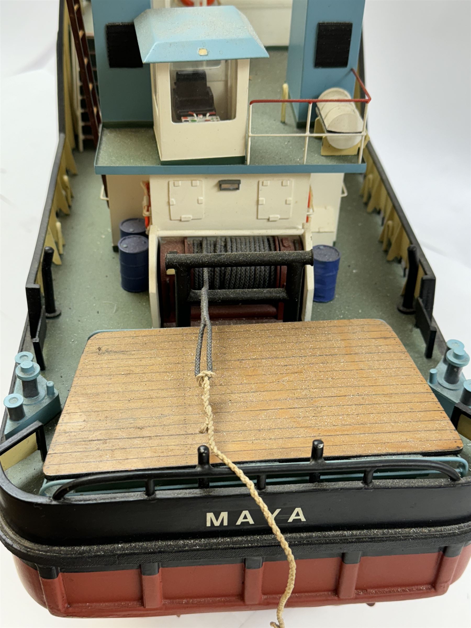 Modern model of American Coastal and River Tugboat 'Maya', in red, black and light blue finish, upon a green stand inscribed with name, H53cm, W52cm 