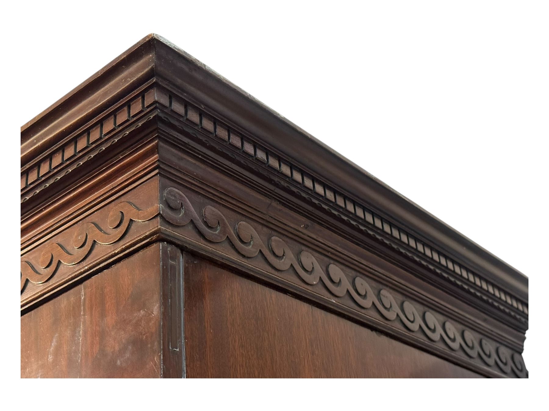 Victorian mahogany linen press, projecting cornice with dentil and scroll detailing, double panelled doors opening to an interior fitted with a brass hanging rail and coat hooks, lower section with two drawers and fitted shelves for additional storage, raised on bracket feet