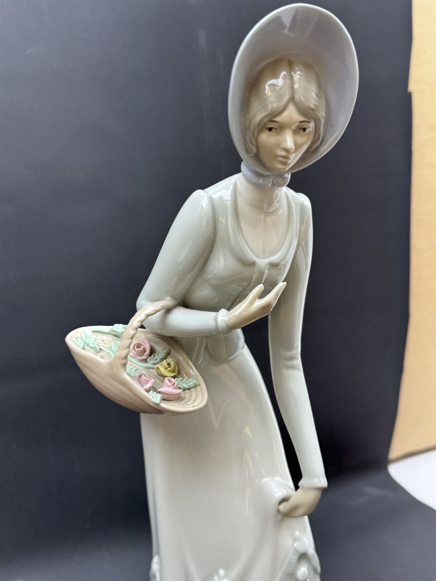 Group of Lladro figures, to include May Dance no 5662, examples modelled as a female golfer, young woman holding sheep in her arms, pair of figures in pink dressed holding sun hats, etc., together with two Nao figures and a further Spanish example, (11)