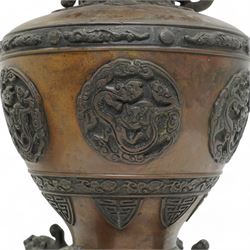 Late 19th/ early 20th century Japanese bronze Usubata vase, the flared top over two Phoenix cast handles, the ovoid body decorated in relief with mythical creatures within roundels, on four open mouth lion mask and scroll supports, H43cm x W24cm 