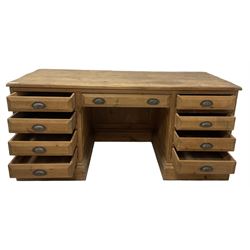 20th century waxed pine kneehole desk, rectangular top over nine drawers with cup handles, on moulded plinth base