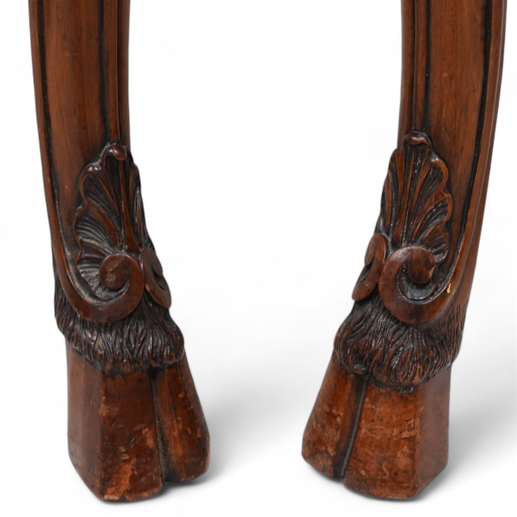 Pair of Georgian walnut console tables, the shaped rectangular cross-banded top with moulded edge over a banded frieze, raised on moulded cabriole supports decorated with scalloped shell and scroll carved knees, terminating to hairy hoof feet