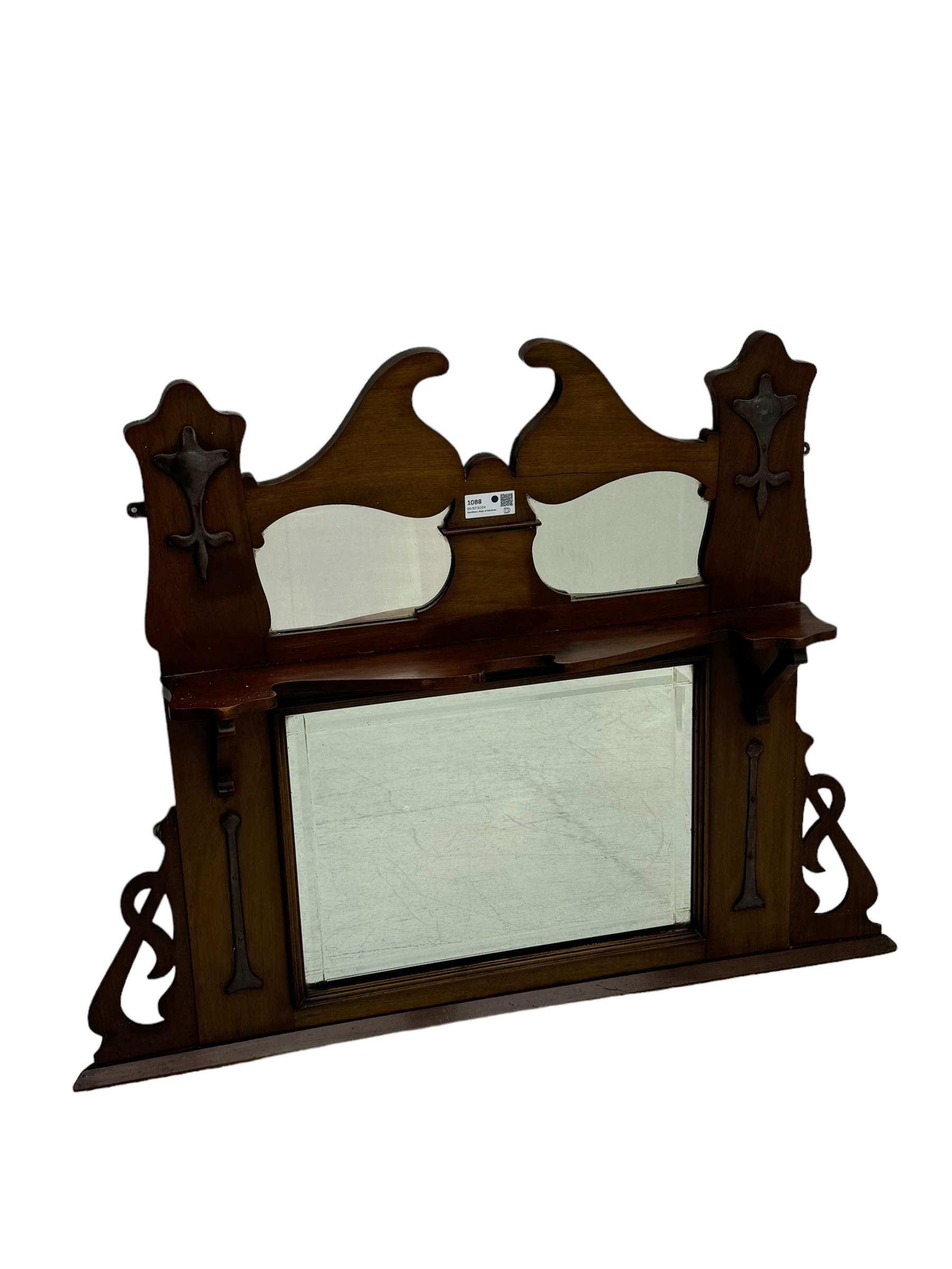 Arts & Crafts period walnut overmantel mirror, shaped pediment over shelf, rectangular bevelled mirror plate within applied mouldings, shaped and pierced corner brackets, decorated with shaped copper mounts 