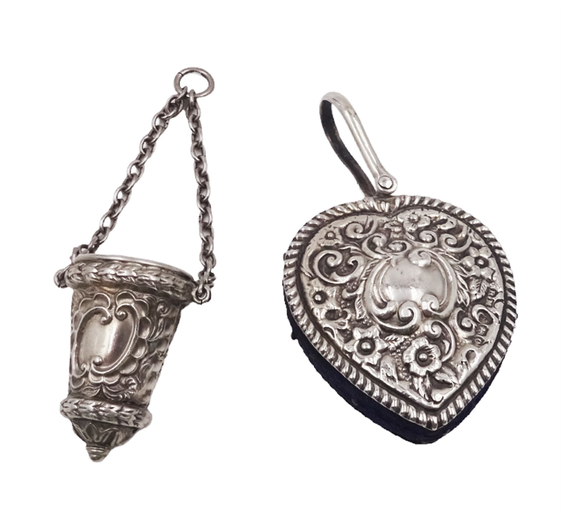 Edwardian silver pin cushion, in the form of a heart, with embossed floral decoration, with blue pin cushion between two heart shaped silver covers, with chatelain hook, hallmarked Henry Matthews, Birmingham 1902, together with a late Victorian silver thimble holder, embossed with scrolling decoration and with velvet interior, with chatelain chain, hallmarked Levi & Salaman, Birmingham 1899, pin cushion H4.5cm