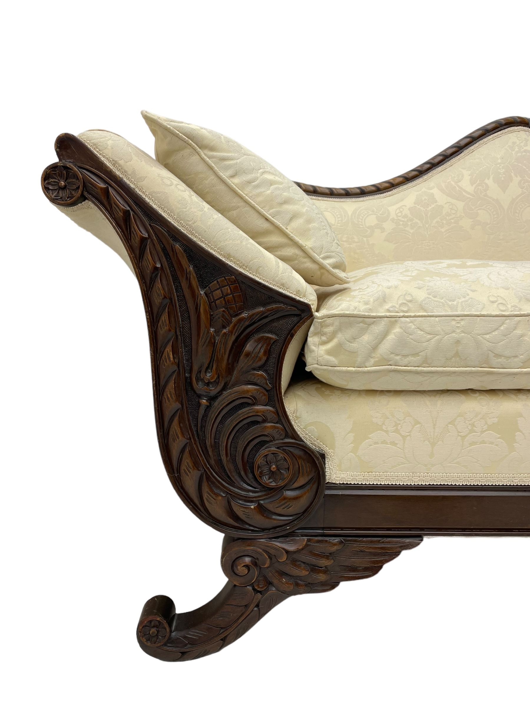 Victorian design walnut framed settee, shaped camelback with gadroon carved edge and central feather motif, upholstered in cream damask fabric with scrolling floral pattern, S-scroll arm facias carved with flower head and curled leaves, feather carved C-scroll splayed feet 