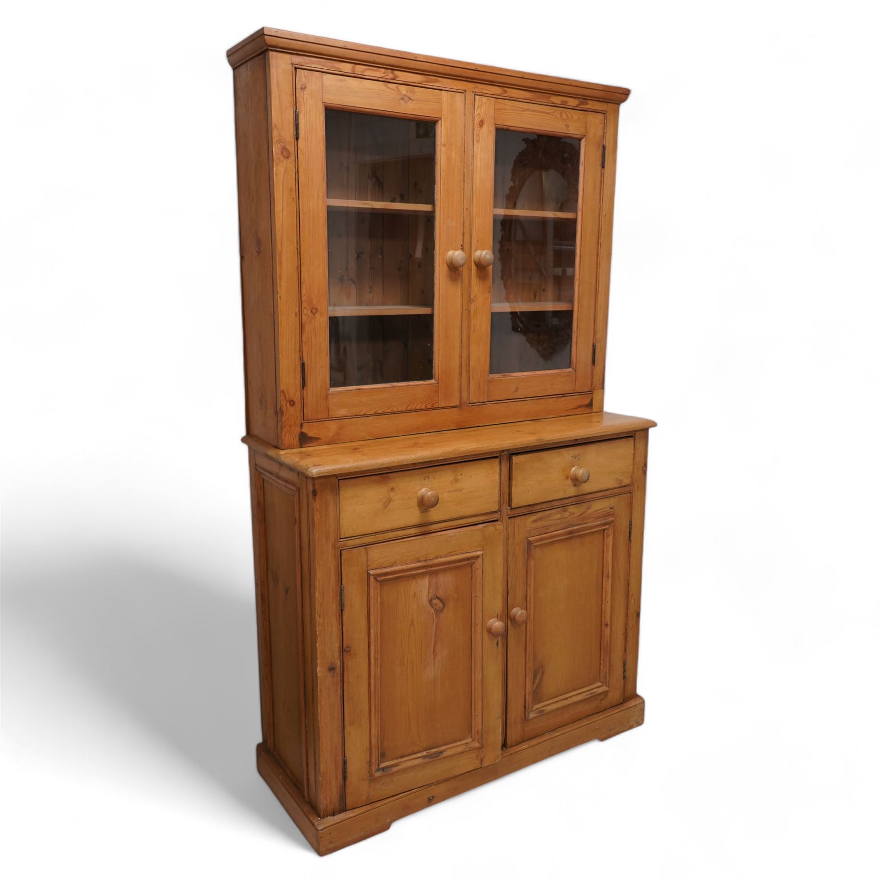 Late 20th century waxed pine dresser, raised display cabinet enclosed by two glazed doors, the base fitted with two drawers over panelled cupboard, on plinth base