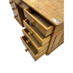 Waxed pine twin pedestal desk, rectangular top over nine drawers, on compressed bun feet 