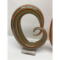 Three art glass sculpture, coiled form with multicolour stranded, upon clear glass plinth, unsigned, largest H27cm