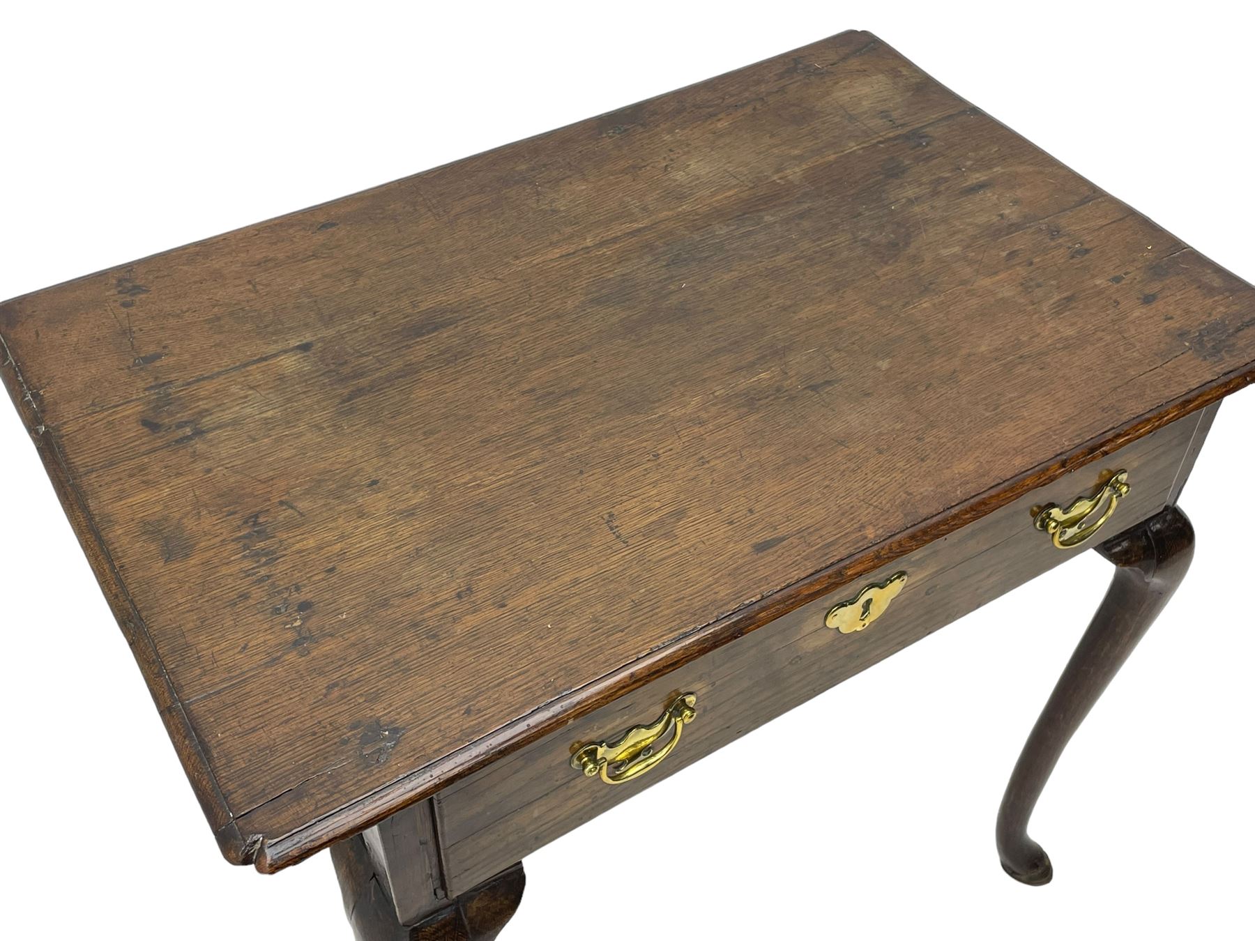 George III oak low-boy, moulded rectangular top with shaped corners, fitted with single drawer, shaped brass handle plates and escutcheon, on cabriole supports 