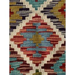 Chobi Kilim ground runner, the field decorated with a geometric pattern of coloured diamonds and triangles, each containing stylised motifs, the shorter ends enclosed by a plain border, and the longer sides with a multicoloured border

