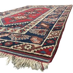 Turkish crimson ground rug, the field decorated with three geometric medallions within a band of star motifs, the main border decorated with stylised plant motifs 