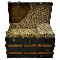 Early 20th century 'McBrine Baggage' steamer trunk, oak frame and black canvas covering, featuring metal hardware and leather straps, fitted with central lock, additional latches, and corner protectors, the interior is lined with floral-patterned paper and includes a removable top tray with makers label 