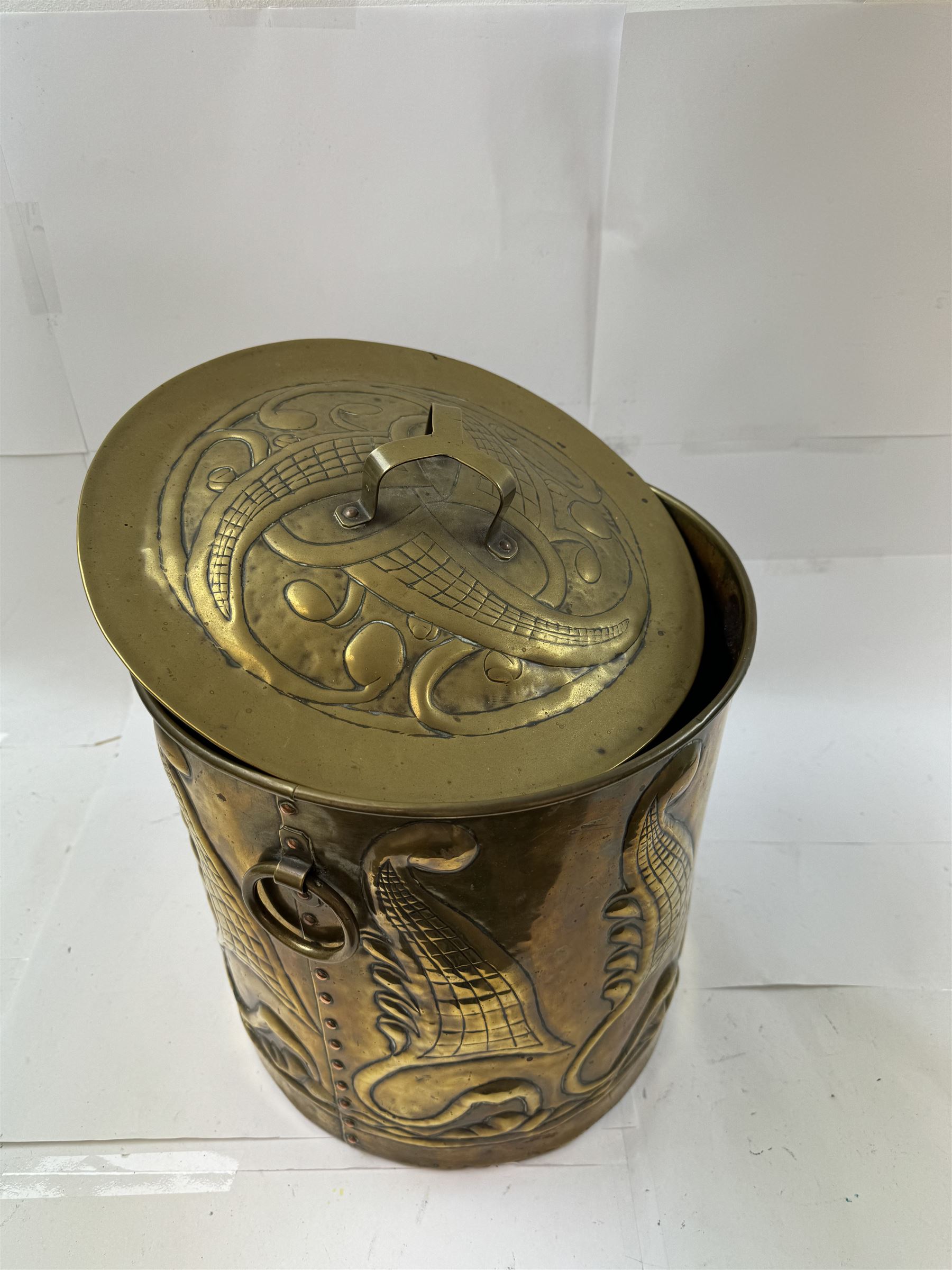 Arts and Craft brass coal box of cylindrical, with embossed stylised leaf panels, with twin handles, the cover with triform handle, H42cm 