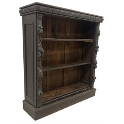 Victorian Jacobean revival carved oak open bookcase, cushion frieze carved with foliate decoration the pilasters decorated with applied carved lion masks and fruit motifs with extending leafage, two shelves over skirted base