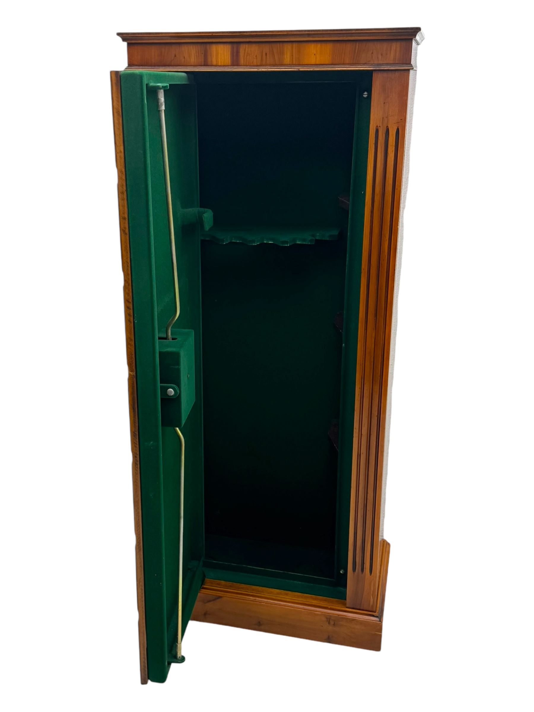 21st century steel lined gun cabinet, modelled as a Wellington chest of yew wood, to hold six long guns, interior lined with green baize, three storage shelves, with keys and bolts 