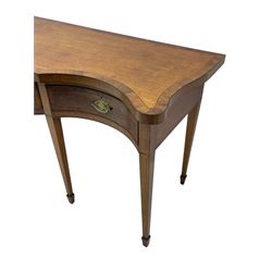 Large George III mahogany serpentine serving table, shaped top with crossing banding and stringing, the frieze fitted with three cock-beaded drawers, oval pressed brass handle plates decorated with urns, on square tapering supports with spade feet 