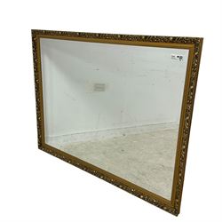 Large rectangular gilt framed wall mirror, decorated with trailing leafy branches and flowerheads, bevelled glass plate 