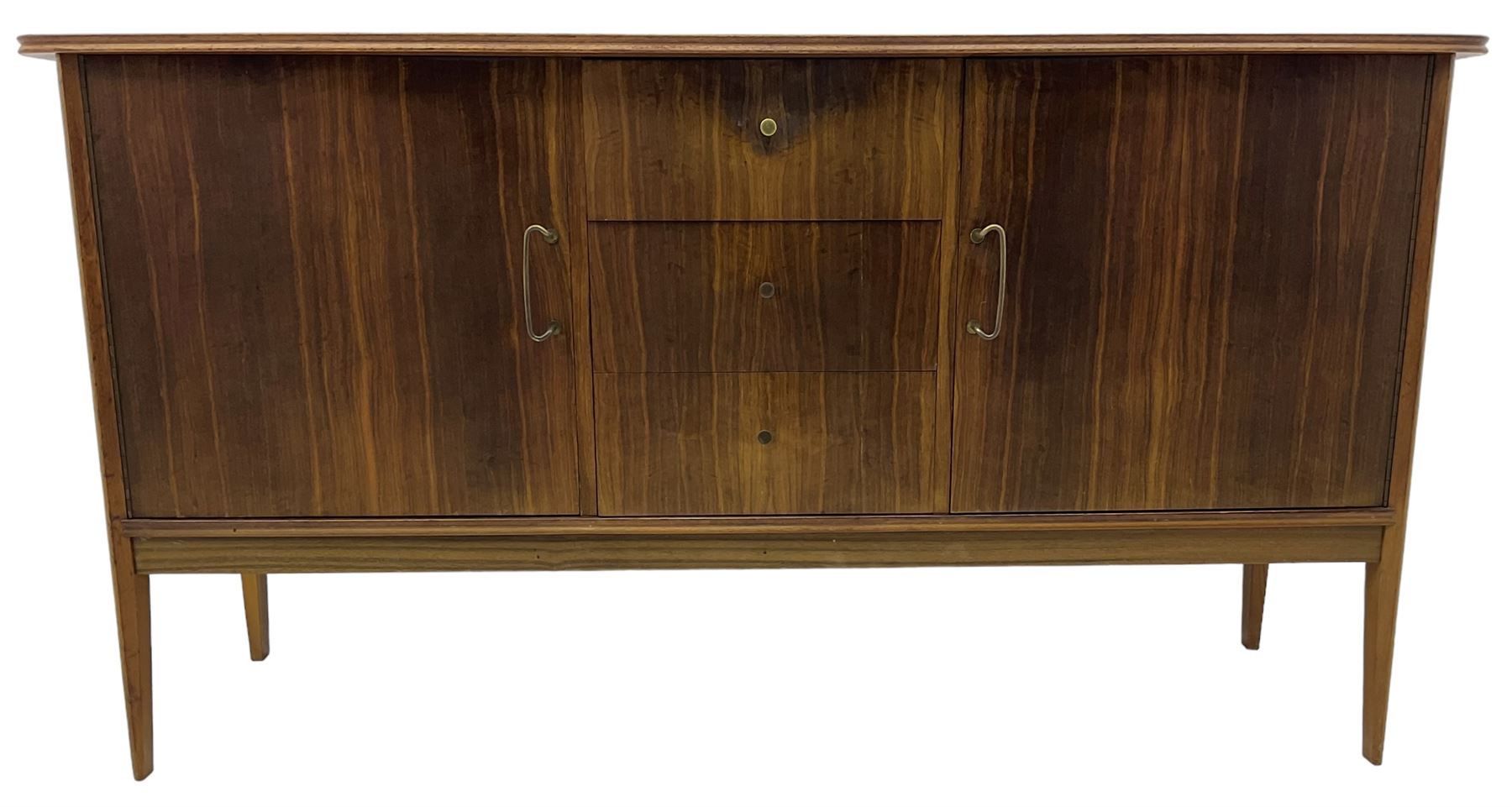 Mid 20th century teak sideboard, rectangular top with rounded corners over three central drawers, flanked by two cupboard doors enclosing shelves, raised on tapered supports