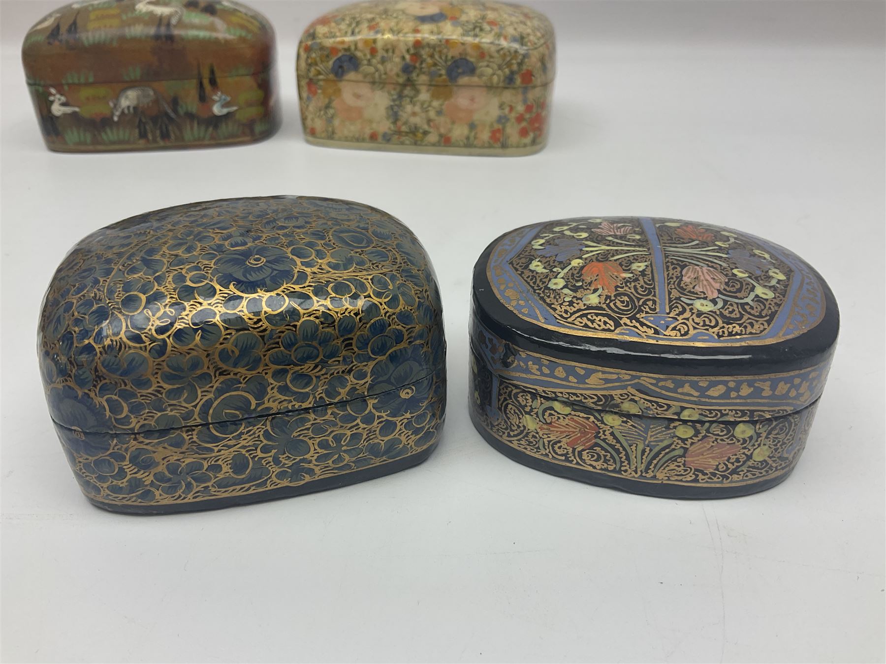 Nine lacquered boxes, all rectangular form, including russian examples decorated with animals within a stylized landscapes and example with flower decoration, largest H7cm, L11cm