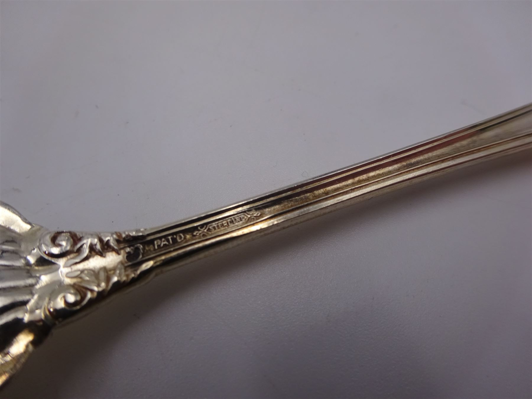 Set of twelve American silver oyster/pickle forks, three pronged forks, the stem decorated with ribbon banding and foliate border surrounding an engraved initial, stamped Sterling 