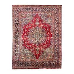 Large Persian Kashan crimson ground carpet, the busy field decorated with a central floral...