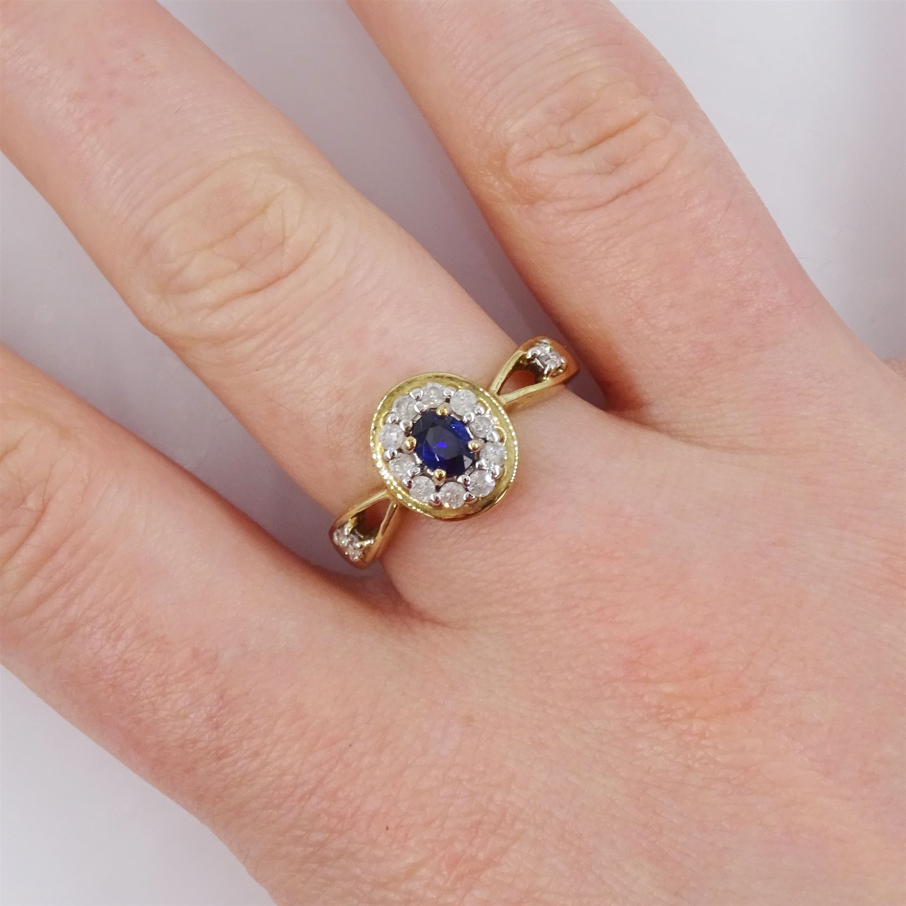 9ct gold oval cut sapphire and round brilliant cut diamond cluster ring, with diamond set shoulders, hallmarked