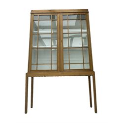 Georgian stripped pine bookcase display cabinet, plain moulded cornice over two glass-panel doors with multiple panes, enclosing white painted interior with three shelves, raised on square supports