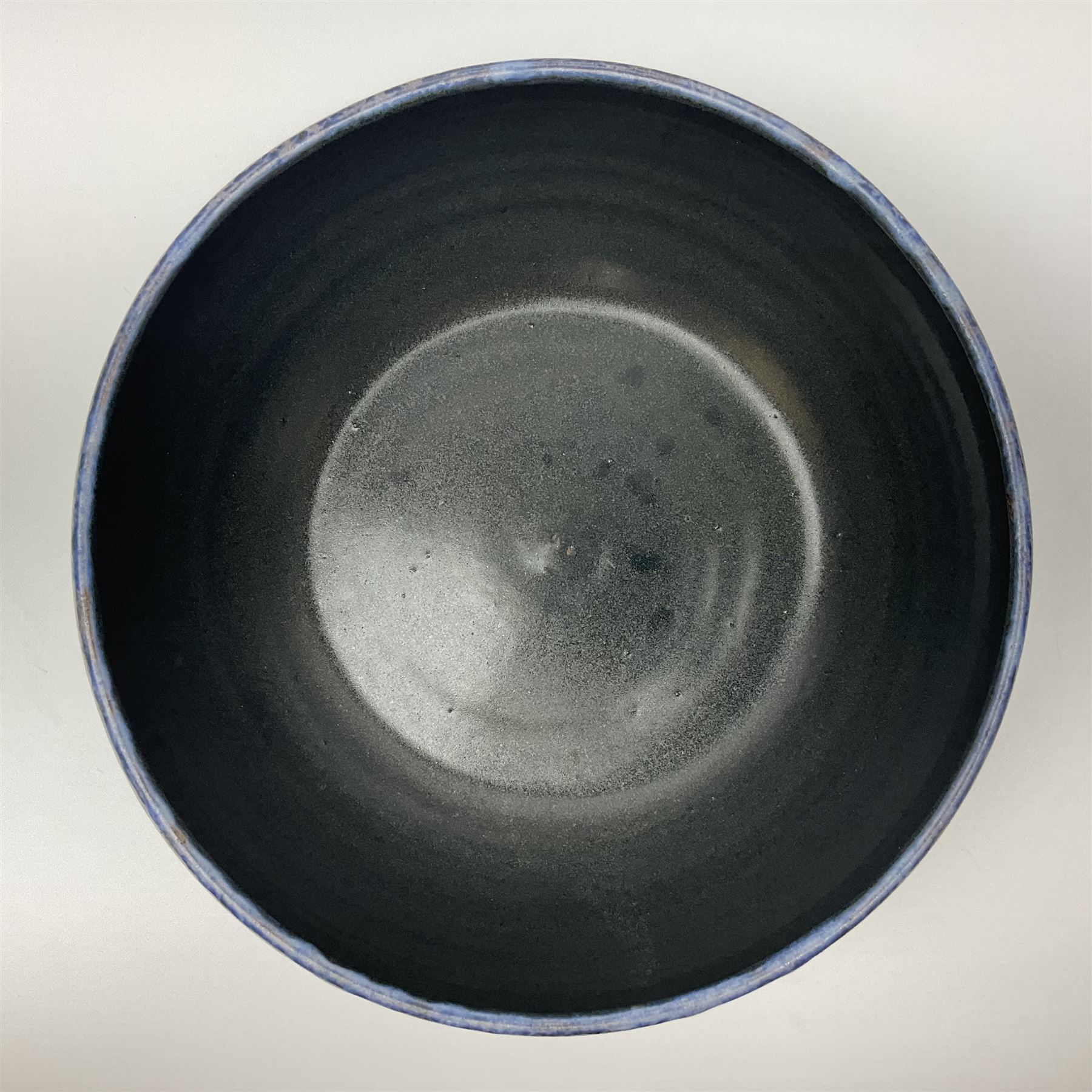 John Egerton (c1945-): studio pottery stoneware serving dish, decorated with abstract floral petals on a dark blue ground, D30cm