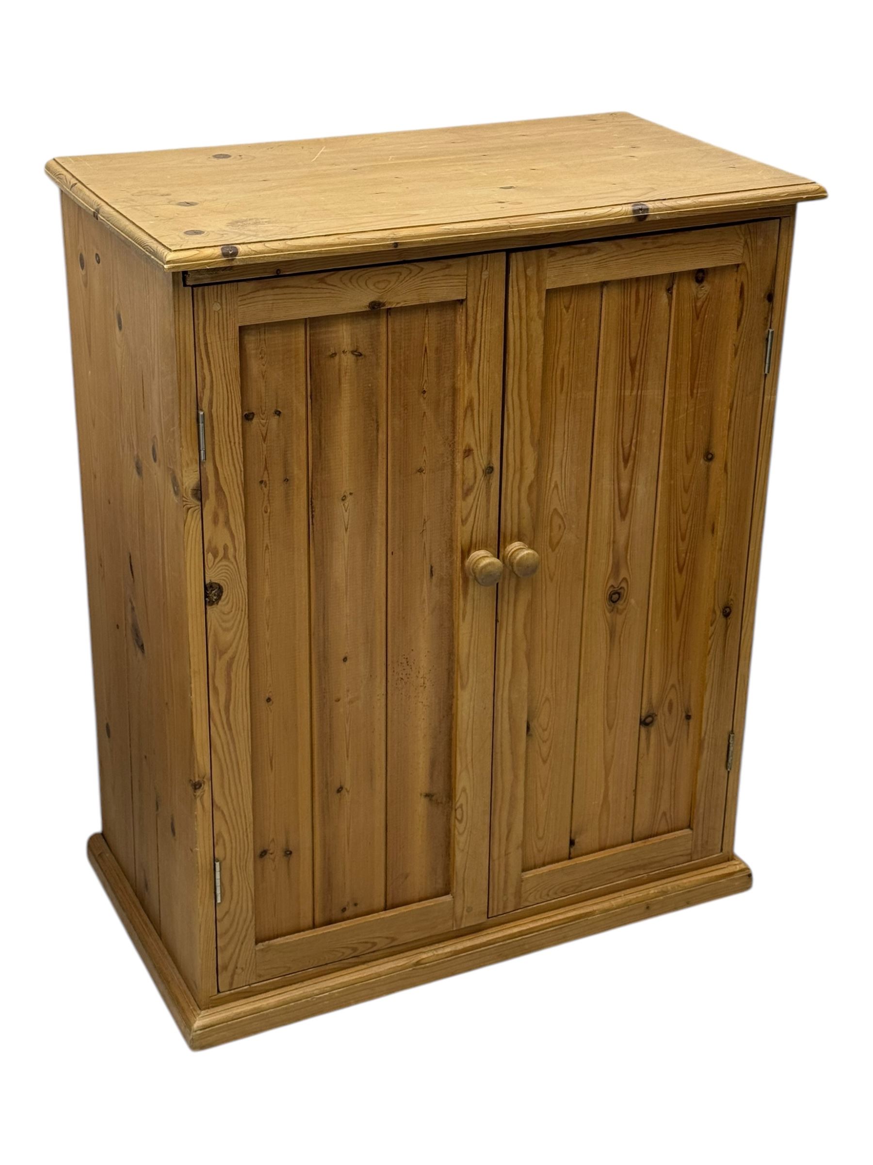 Pine cupboard, rectangular moulded top over two panelled doors enclosing two plank shelves, on plinth base