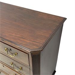 Small George III mahogany chest, rectangular canted form, moulded top over two short and three long cock-beaded drawers, fitted with brass swan neck handles and oval plates, enclosed by fluted upright corners, on bracket feet 