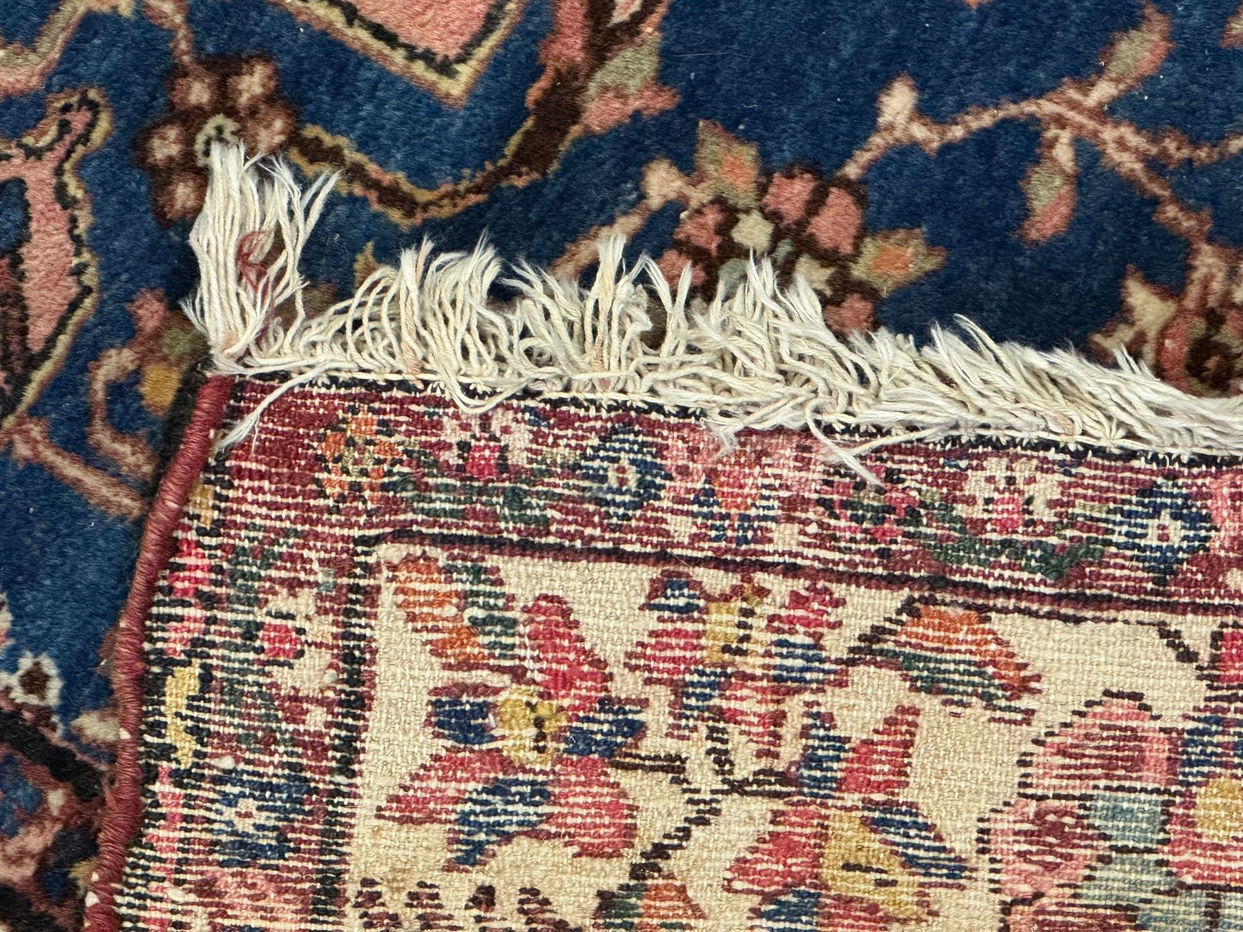 Persian Hamadan ground rug, central medallion design with a salmon pink field, accentuated by navy blue spandrels, surrounded by a stylised floral border in cream and blue tones