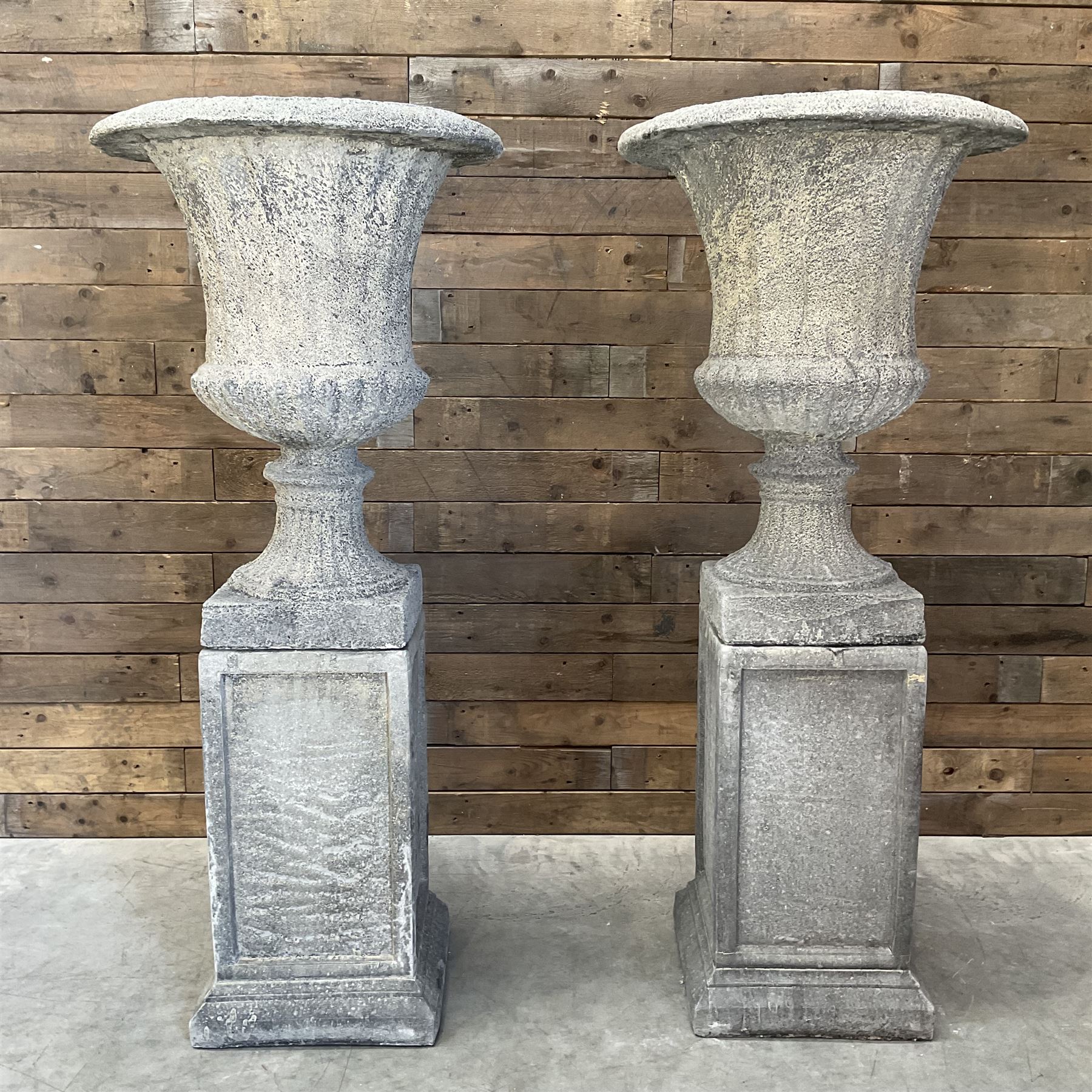 Pair of large Georgian design cast stone garden urns, egg and dart border, tapering column on square base, raised on square column