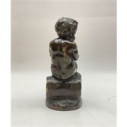 Bronzed metal model of a putti seated upon a barrel with goblet in hands, and fruiting vines adorning their head, H17.5cm