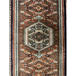 North West Persian Bidjar rug, orange peach ground extended field on indigo ground, decorated with floral Herati motifs, repeating waved border decorated with stylised plant motifs