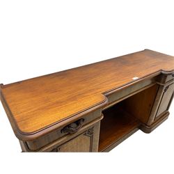 Mid-19th century figured mahogany sideboard, moulded reverse-break front, fitted with three drawers and two cupboards, carved faux bois handles, enclosed by panelled doors with book-matched veneers, applied geometric mouldings and scroll leaf decoration, on moulded plinth base 