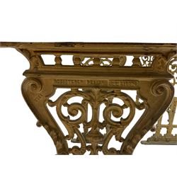 Pair of 19th century cast iron entrance tables, rectangular marble top over ornate gilt bases with scrolling foliate design and sledge feet, united by balustrade stretcher with scroll spandrels