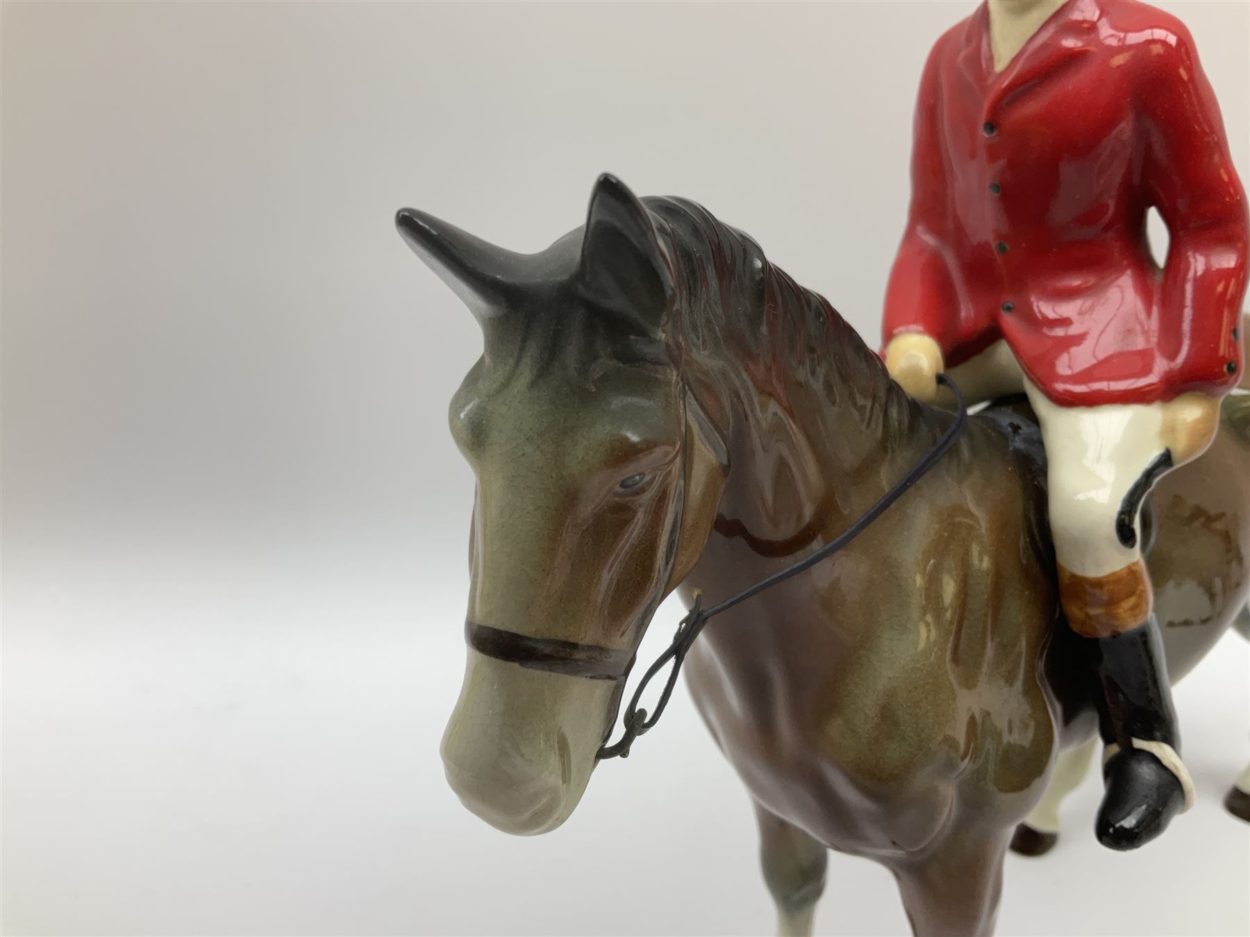 Beswick Hunting Group, comprising: two huntswoman on grey horses, model no 1730, huntsman on a bay horse, model no 1501, a seated fox, model no 1748, eighteen fox hounds and a spaniel, model no 967, all with printed marks beneath, together with three other ceramic huntsman on horseback and two hounds. 