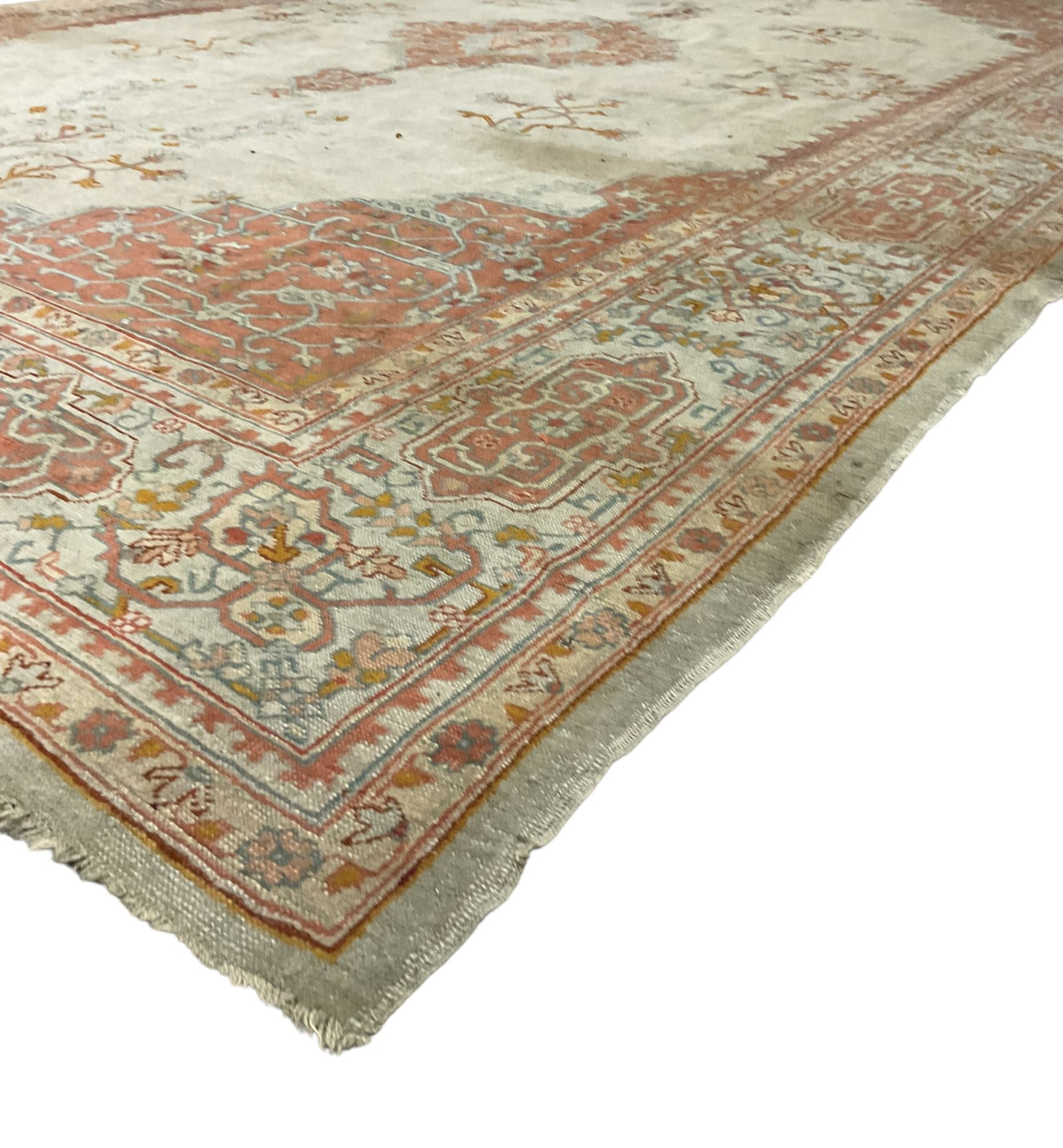 Large Persian pale sage ground carpet, the field decorated with central geometric medallion and tree of life motifs, the border with repeating geometric design decorated with stylised plant motifs