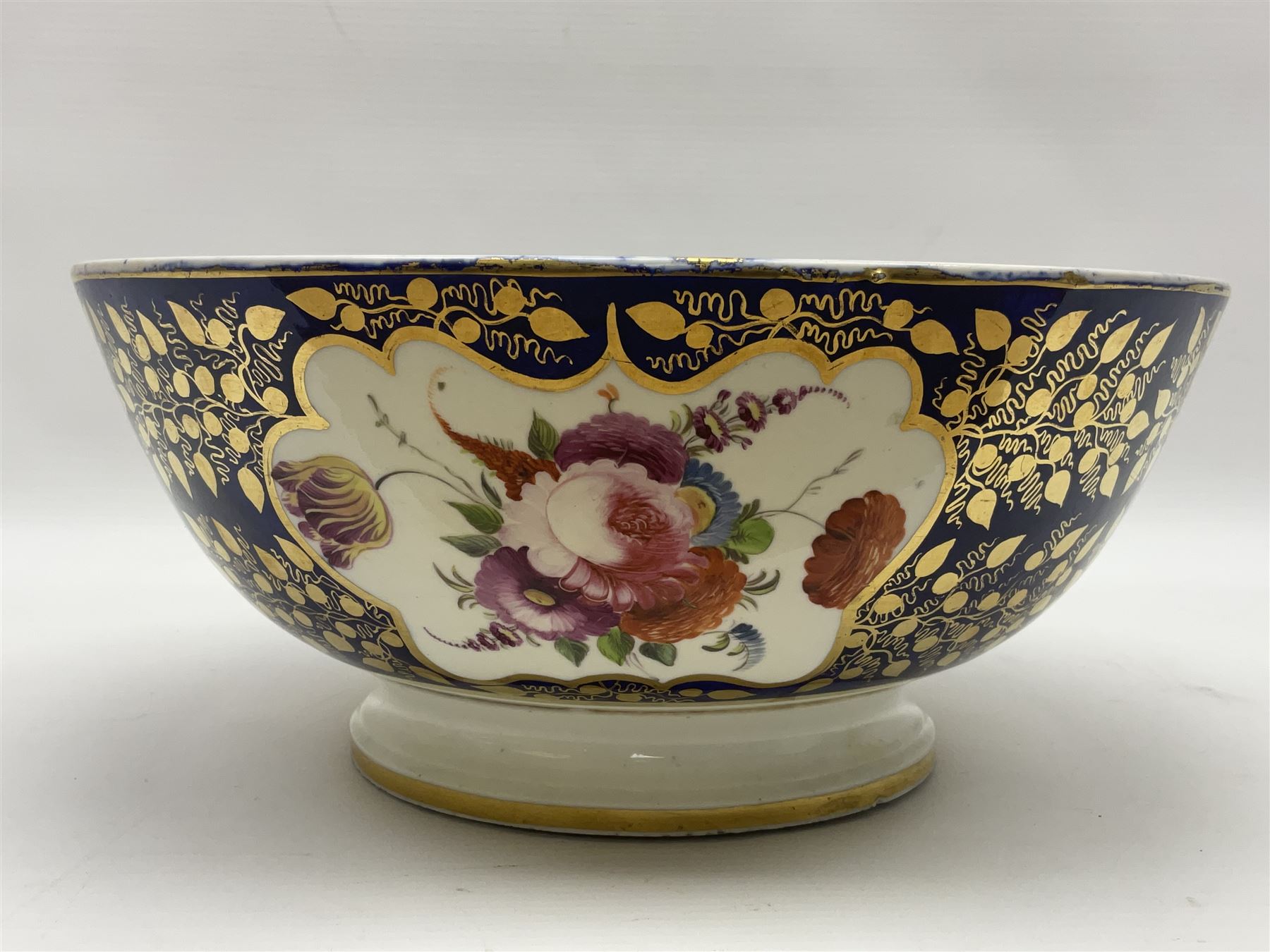 19th century continental bowl, decorated with hand painted floral sprays amongst gilt foliate decoration on a cobalt blue ground, D27.5cm