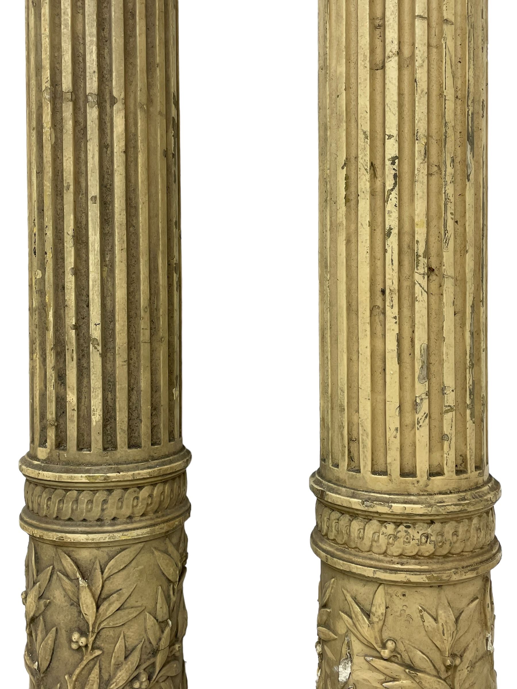 Three 19th century wood and gesso Composite order architectural architraves - curled acanthus leaf capitals over fluted shafts, the bases decorated with guilloche moulding over trailing laurel leaf branches, one half columns, one L-shaped rectangular pilaster and one full column, the largest - H204cm