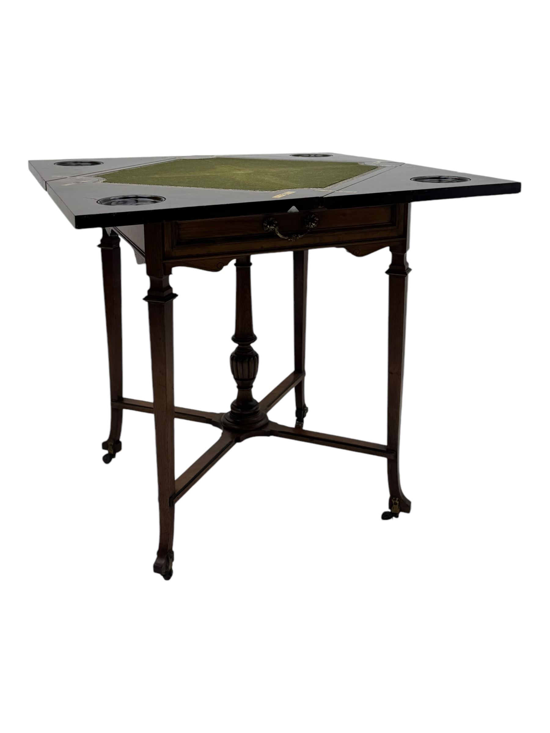 Victorian rosewood envelope games table, the moulded square top with four triangular hinged leaves, revealing inset baize playing surface and sunken counter wells, fitted with single frieze drawer, on square tapering supports united by x-framed stretchers and turned central column, on brass and ceramic castors 