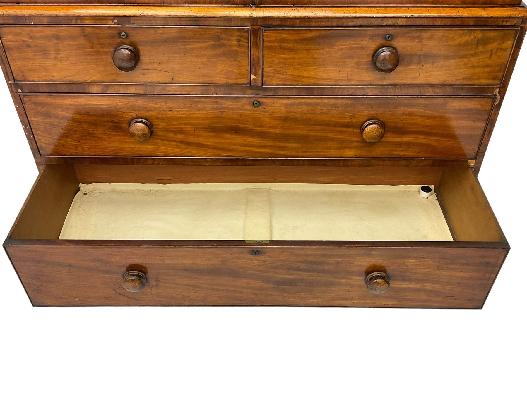 Victorian figured mahogany linen-press, projecting moulded cornice over two arch panelled doors, fitted with two short and two long cock-beaded drawers, on turned feet