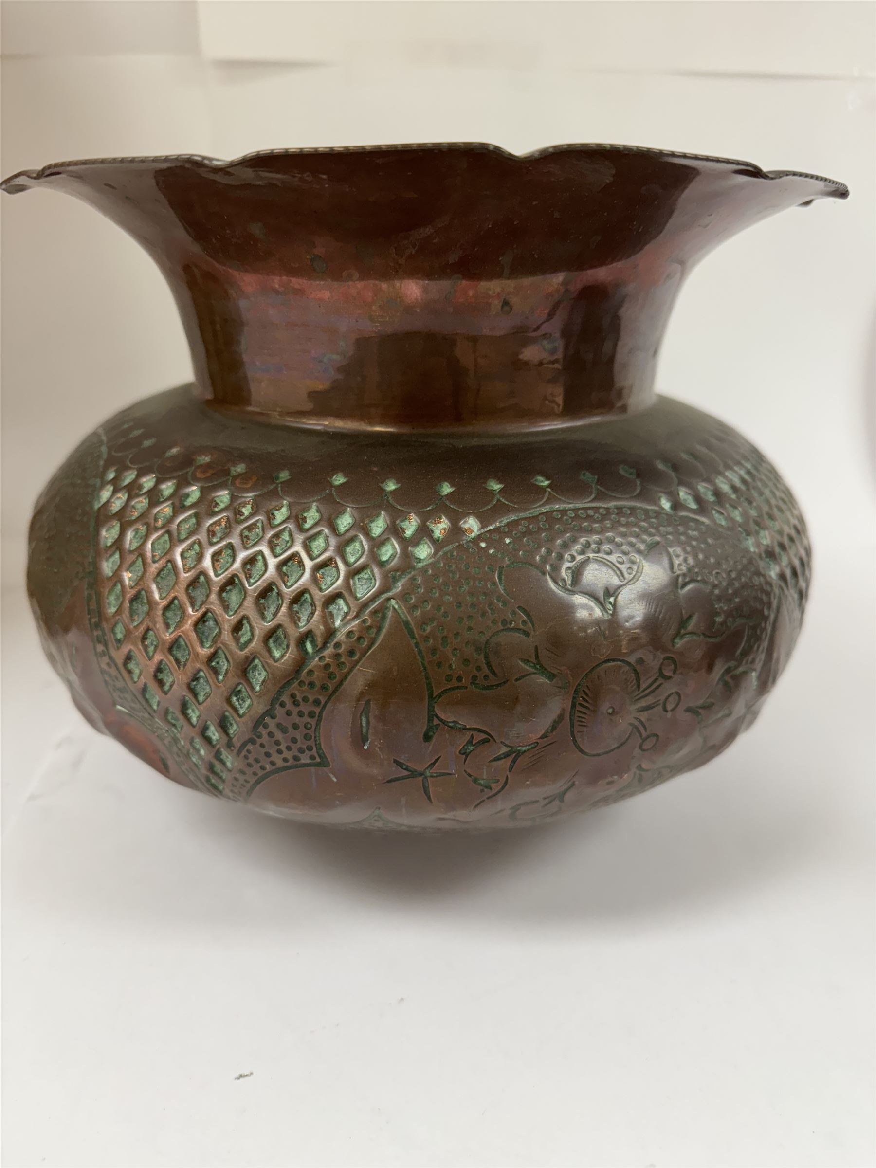 Middle eastern copper bucket, with chased and embossed band of animal decoration, together with a copper jardinière embossed with floral panels, copper plate with embossed leaf motif and two brass helmet shaped coal scuttles, bucket H26cm