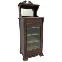 Edwardian walnut music cabinet, raised bevelled mirror back with shaped pediment, fabric lined interior with three shelves enclosed by bevel glazed doors, on shaped bracket feet