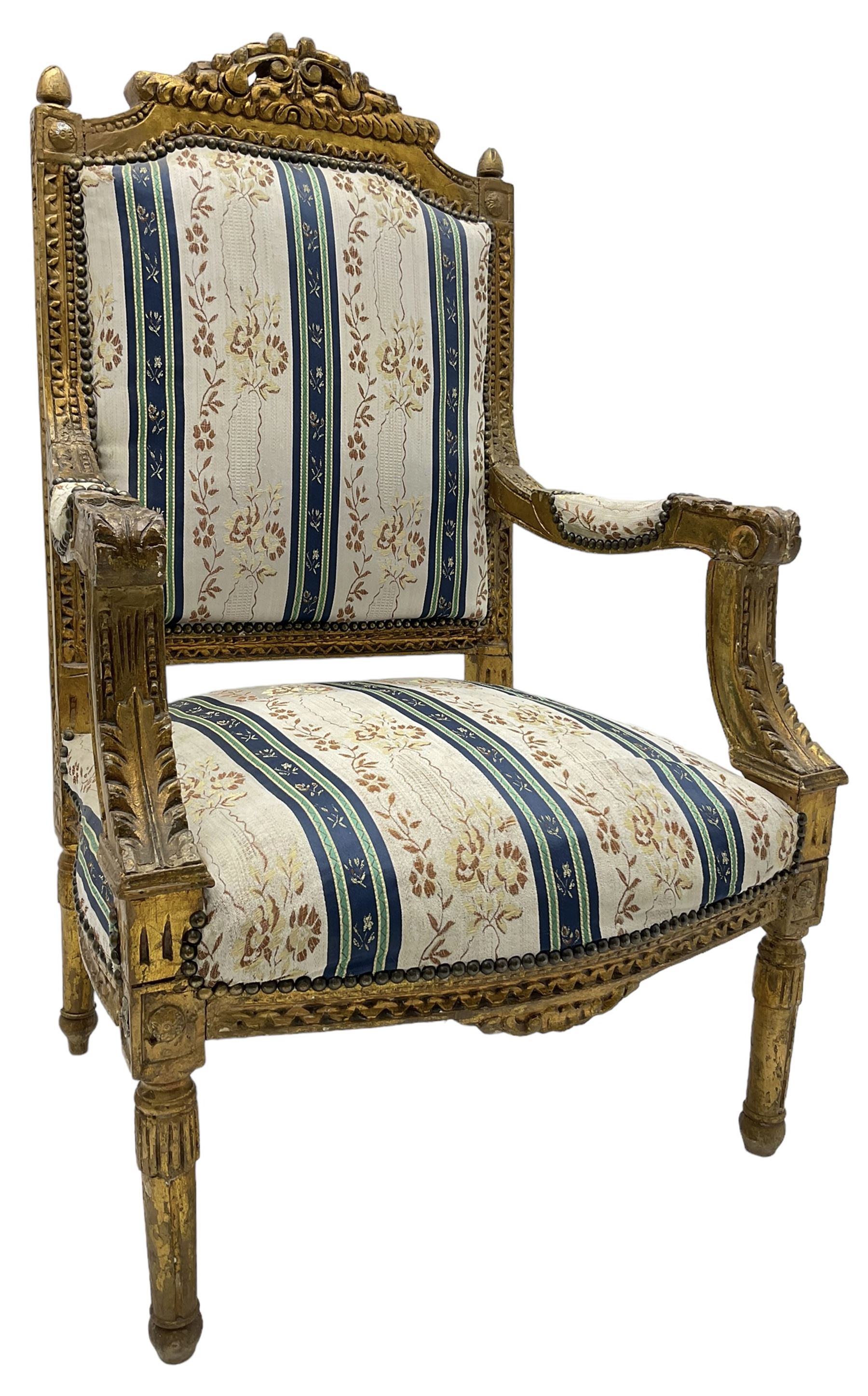 Late 20th century French design carved giltwood armchair, the cresting rail carved with scrolled foliage over foliate carved platform, upholstered in striped fabric decorated with trailing foliage and flower heads, acanthus carved arm terminals and upright supports, on turned and fluted supports 