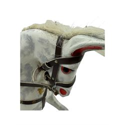 Mid 20th century rocking horse, dappled grey painted horse with applied mane and tail, red leather saddle and bridle accented with brass studs, supported by a stained wooden frame with turned supports and iron brackets, mounted on rockers